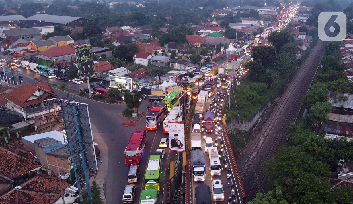<p>Foto udara memperlihatkan kondisi lalu lintas di Simpang Jomin Pantura, Cikampek, Jawa Barat, Jumat (29/4/2022). Memasuki H-3 Idul Fitri, jalur mudik didominasi oleh kendaraan roda dua, truck dan mobil. (merdeka.com/Imam Buhori)</p>