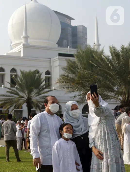 Umat muslim berswafoto usai melaksanakan shalat Idul Fitri 1442 H di Lapangan Masjid Agung Al Azhar, Jakarta, Kamis (13/5/2021). Ribuan umat muslim melaksanakan shalat Idul Fitri 1442 H di Lapangan Masjid Agung Al Azhar dengan menerapkan protokol kesehatan ketat. (Liputan6..com/Helmi Fithriansyah)