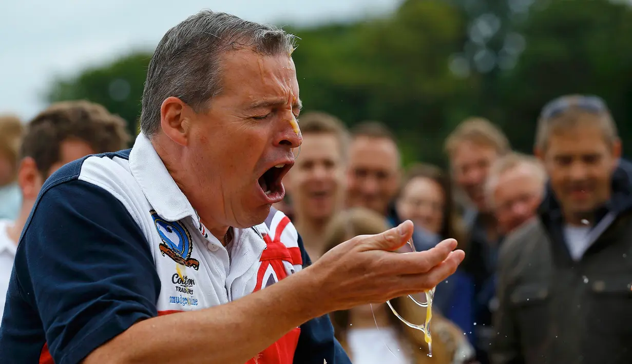 Ekpresi seorang pria saat memecahkan telur dikepalanya usai kalah dalam permainan Russian Egg Roulette pada acara Kompetisi Melempar Telur Dunia dan Vintage Day di Swaton, Inggris, Minggu (28/6/2015). (REUTERS/Darren Staples)