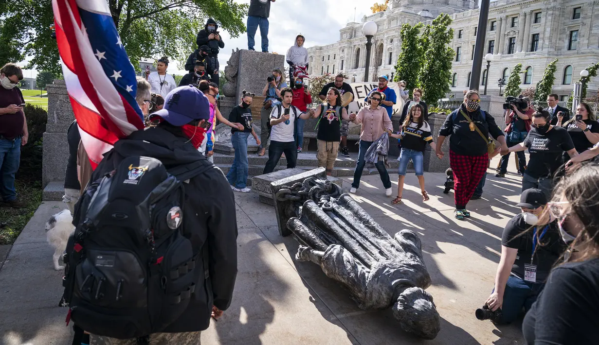 Sekelompok massa menari setelah merobohkan patung Christopher Columbus di Minnesota State Capitol, St. Paul, Minnesota, Amerika Serikat, Rabu (10/6/2020). Patung Christopher Columbus jadi amukan massa setelah kematian George Floyd. (Leila Navidi / Star Tribune via AP)