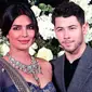 Pasangan aktris Bollywood Priyanka Chopra dan musisi Nick Jonas berpose untuk resepsi kedua pernikahan mereka di Mumbai, India, Rabu (19/12). Nick dan Priyanka sengaja membuat pesta khusus untuk berbagi kebahagiaan dengan awak media. (AP/Rajanish Kakade)