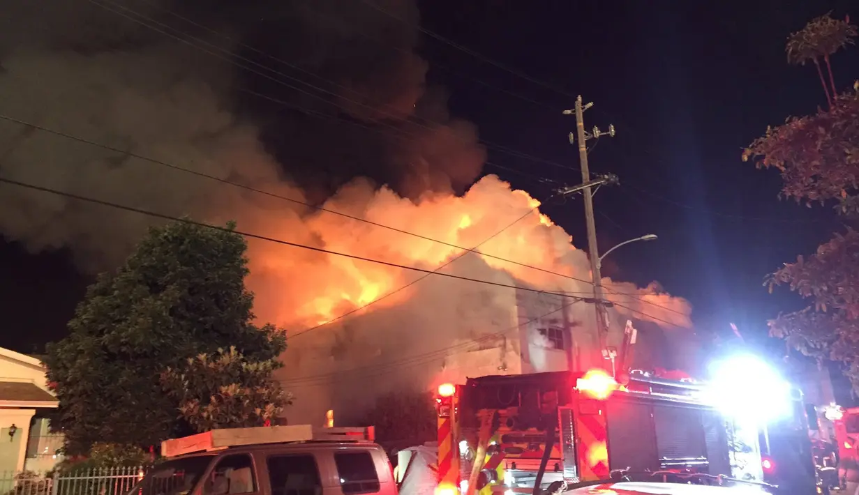 Kebakaran besar menghanguskan sebuah  gudang yang diubah menjadi kelab malam di Oakland, California, Sabtu (3/12). Sedikitnya sembilan orang dikonfirmasi tewas, kebanyakan ditemukan petugas di lantai dua bangunan. (Seung Lee/Handout via Reuters)