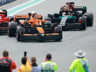 Pembalap McLaren, Lando Norris bersama Oscar Piastri menyapa para penonton disusul pembalap Ferrari, Charles Leclerc dan Lewis Hamilton (kiri) serta pembalap Mercedes, George Russell dan Kimi Antonelli saat melakukan parede mobil lego sebelum balapan Formula 1 GP Miami 2025 yang berlangsung di Sirkuit Autodromo, Miami, Florida, Minggu (04/05/2025) waktu setempat. (AFP/Hector Vivas)