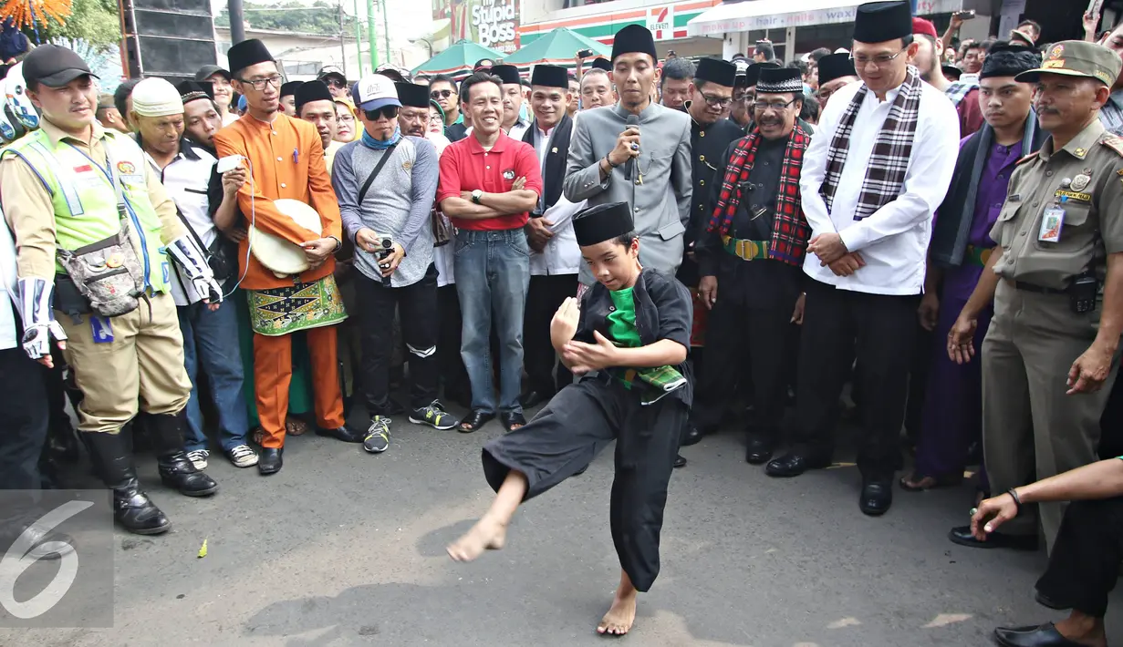 Gubernur DKI Jakarta Basuki T Purnama melihat aksi bocah di Festival Palang Pintu 2016 di Kemang, Jakarta, (28/5). Event tahunan tersebut diselenggarakan merayakan HUT ke-489 DKI Jakarta yang digelar pada 28-29 Mei 2016. (Liputan6.com/Immanuel Antonius)