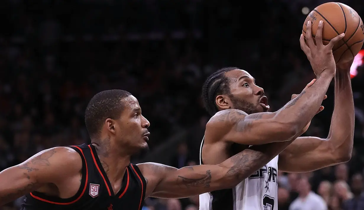 Pebasket Houston Rockets, Trevor Ariza, berusaha menghentikan pebasket San Antonio Spurs, Kawhi Leonard, pada laga semifinal wilayah barat NBA di AT&T Center, San Antonio, Rabu (3/5/2017). Spurs menang 121-96 atas Rockets. (AFP/Ronald Martinez)