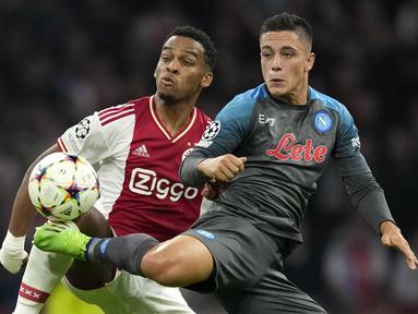 Bek Ajax Amsterdam Jurrien Timber menantang penyerang Napoli Giacomo Raspadori pada matchday ketiga Grup A Liga Champions 2022/2023 di Johan Cruijff ArenA, Rabu (5.10.2022) dini hari WIB. Napoli cukur tuan rumah Ajax Amsterdam 6-1 setelah  ketinggalan lebih dahulu lewat gol Mohammed Kudus. (AP Photo/Peter Dejong)