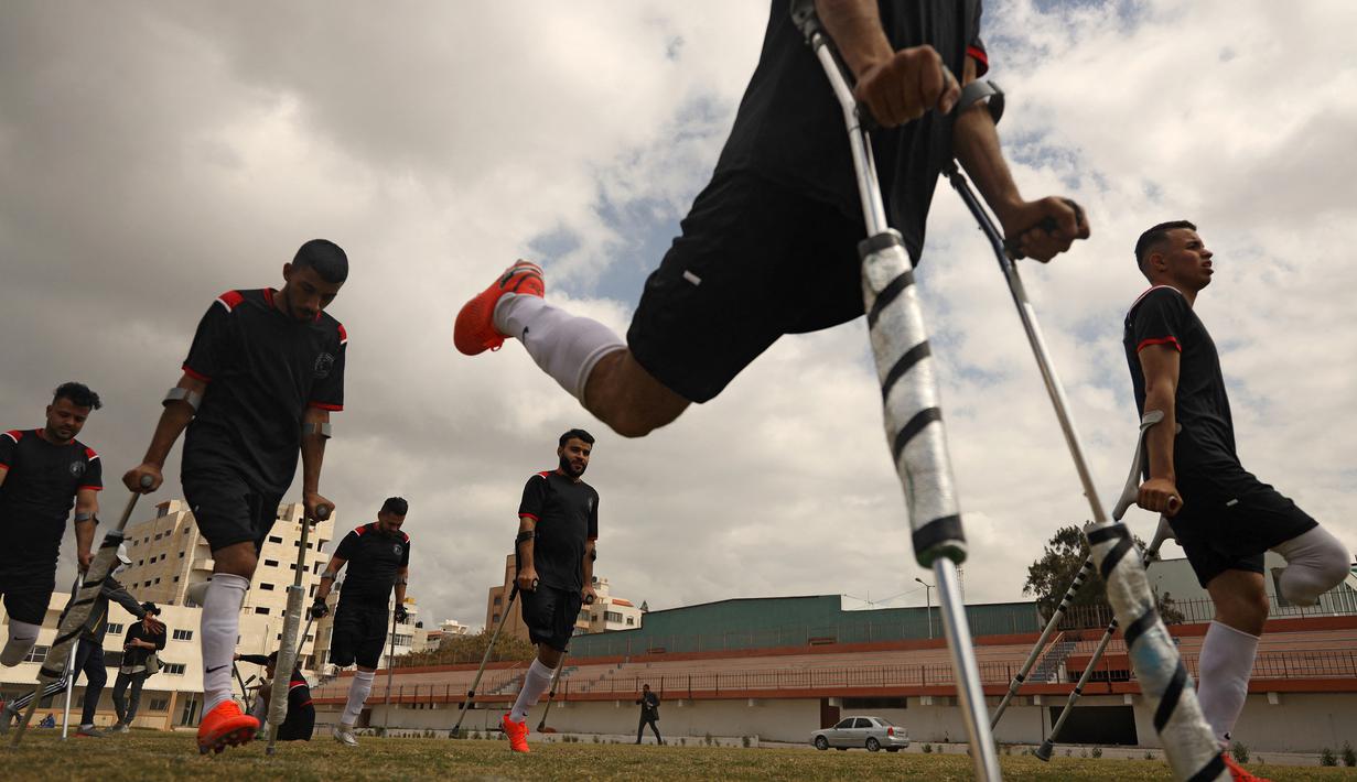 Para pemain klub Al-Jazeera melakukan pemanasan menjelang pertandingan final kejuaraan lokal sepak bola korban amputasi melawan Al-Abtal yang diselenggarakan oleh Komite Palang Merah Internasional (ICRC), di tengah pandemi COVID-19, di Kota Gaza, Palestina, (18/3/2021). (AFP/Mohammed Abed)
