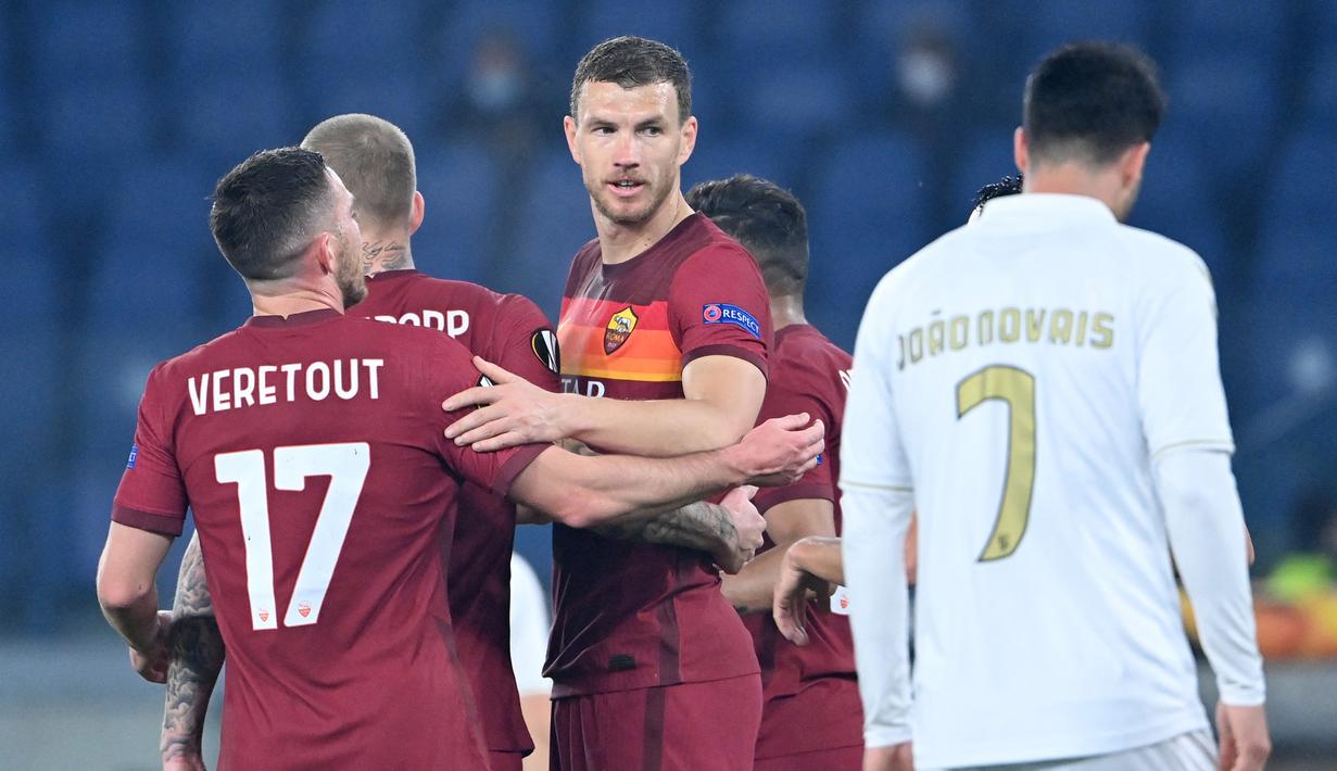 Striker AS Roma, Edin Dezko (tengah) merayakan gol pertama timnya yang dicetak ke gawang SC Braga dalam laga leg kedua babak 32 Besar Liga Europa 2020/21 di Olimpico Stadium, Kamis (25/2/2021). AS Roma menang 3-1 atas SC Braga dan lolos ke babak 16 Besar. (AFP/Alberto Pizzoli)