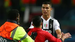 Seorang fans Mancheter United berlari menghampiri penyerang Juventus, Cristiano Ronaldo usai pertandingan grup H Liga Champions di Trafford, Inggris (23/10). Juventus mengalahkan MU dengan skor 1-0 berkat gol Paulo Dybala. (AP Photo/Dave Thompson)