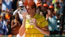 Petenis AS, John Isner mencium trofi usai meraih gelar juara Miami Terbuka 2018 di Key Biscayne, Minggu (1/4). Pada laga final yang menegangkan itu, Isner sukses menaklukkan petenis Jerman Alexander Zverev 6-7, 6-4, 6-4. (Michael Reaves/GETTY IMAGES/AFP)