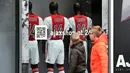 Anak-anak memperhatikan jersey dengan nama Johan Cruyff pada toko di sekitar Stadion Amsterdam Arena, Amsterdam, Kamis (24/3/2016). Bersama Barcelona, Cruyff mempersembahkan dua gelar, yakni Liga Spanyol dan Copa del Rey. (AFP/Franck Fife)