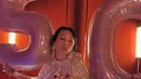 Di ruangan dengan nuansa merah ini, Tata terlihat memegang balon angka 5 dan 0 dengan ukuran cukup besar, menandakan usia barunya. Tampak ia pun mendapatkan cake pink sesuai dengan warna balonnya.  [@tatacahyani]