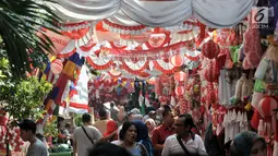 Pengunjung melintasi deretan kios pedagang musiman bendera Merah Putih dan pernak-pernik Hari Kemerdekaan yang memenuhi Pasar Jatinegara, Jakarta, Kamis (1/8/2019). Menjelang perayaan 17 Agustus, banyak pedagang musiman di Jakarta yang menjual pernak-pernik kemerdekaan. (merdeka.com/Iqbal S Nugroho)