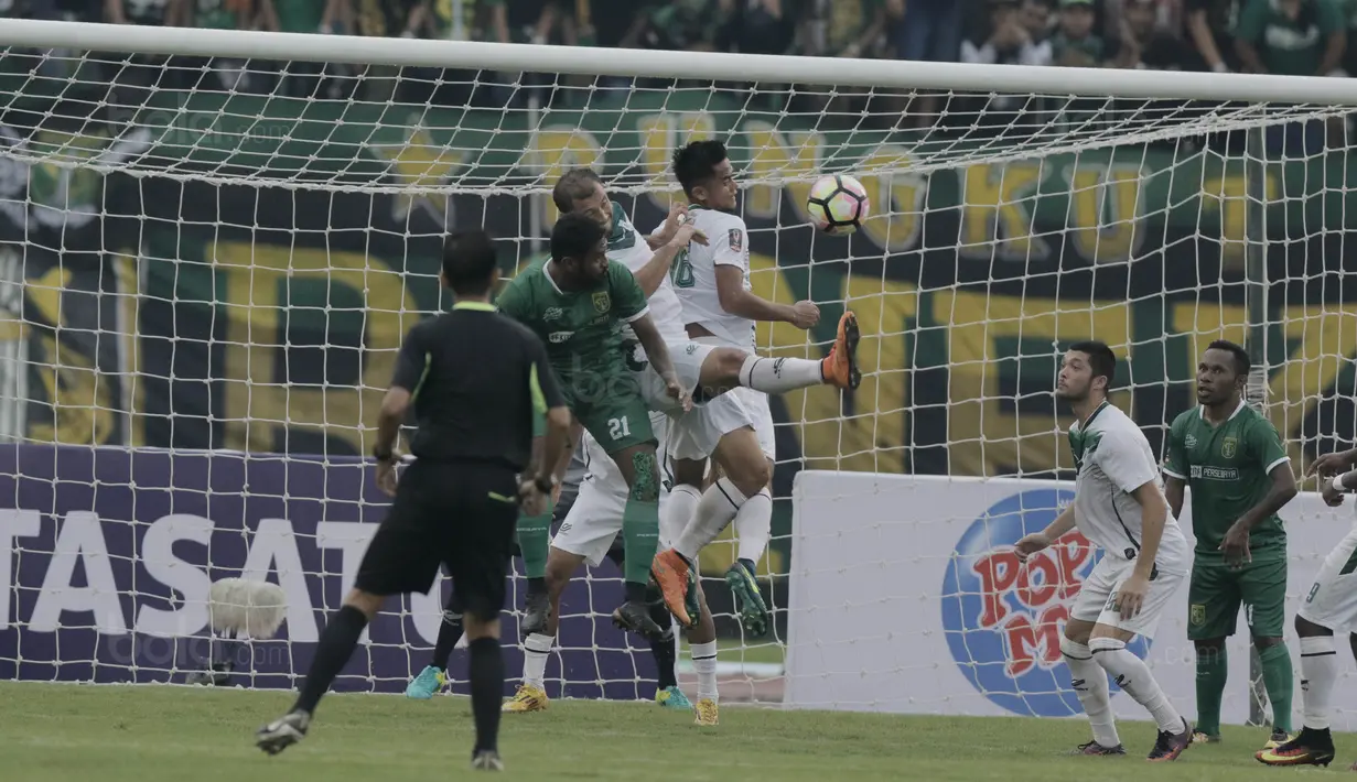 Bek PSMS, M Roby, duel udara dengan bek Persebaya, Fandry Imbiri, pada laga perempat final Piala Presiden di Stadion Manahan, Solo, Sabtu, (3/2/2018). PSMS menang adu penalti atas Persebaya dengan skor 4-3. (Bola.com/M Iqbal Ichsan)