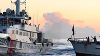 Sebuah kapal Penjaga Pantai China (Kiri) memblokir kapal pasokan sewaan dalam misi mengirimkan perbekalan ke kapal Angkatan Laut Filipina yang dilarang terbang di Second Thomas Shoal di Laut China Selatan. (Jam Sta Rosa/AFP)