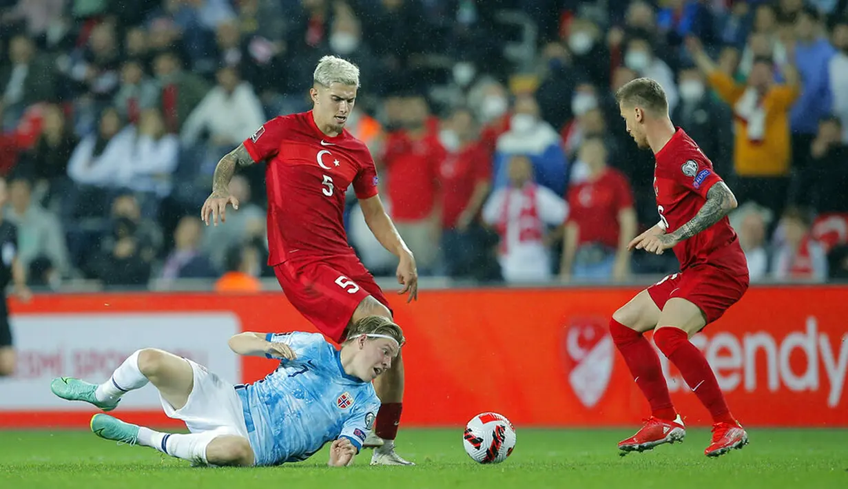 Pemain Norwegia Jens Petter Hauge (bawah) melihat bola di depan pemain Turki Berat Ozdemir pada pertandingan kualifikasi Grup G Piala Dunia 2022 di Stadion Sukru Saracoglu, Istanbul, Turki, 8 Oktober 2021. Pertandingan berakhir dengan skor 1-1. (AP Photo)