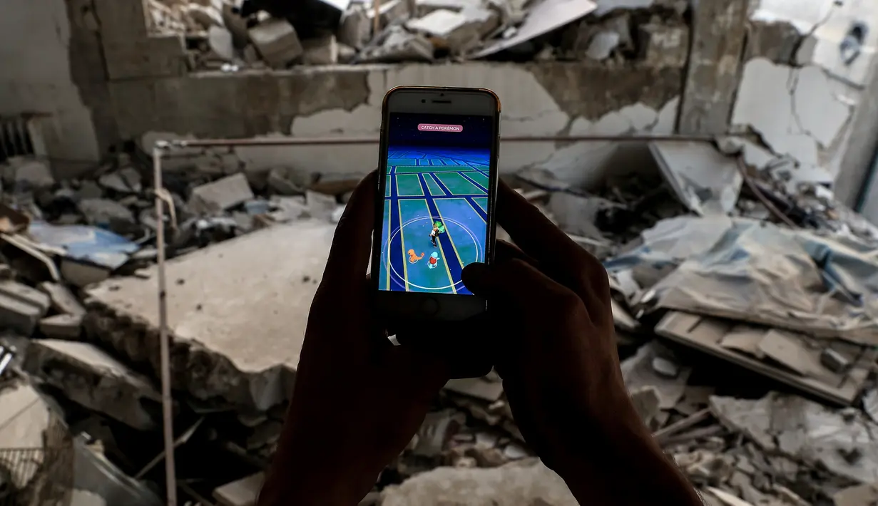 Daerah konflik di Suriah yang penuh dengan puing dan reruntuhan bangunan dijadikan tempat untuk bermain Pokemon Go oleh seorang gamer Suriah, Damaskus (23/7). (AFP PHOTO / Sameer Al-Doumy)