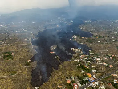 Lava dari letusan gunung berapi Cumbre Vieja mengalir menghancurkan rumah-rumah di pulau La Palma di Kepulauan Canary, Spanyol, Selasa (21/9/2021). Lava yang mengalir dari letusan gunung berapi itu memaksa evakuasi sekitar 5.500 orang dan menghancurkan sedikitnya 100 rumah. (AP/Emilio Morenatti)