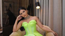 Berpose di sebuah sofa, Jessica Mila berpenampilan cukup nyentrik dan menyilaukan mata. Ia tampi mengenakan Dress berwarna hijau berbentuk kemben dengan banyak detail di bagian pinggang. Belahan dress cukup tinggi hingga atas lutut. (Instagram/jscmila)
