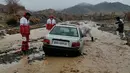 Petugas membantu kendaraan yang terjebak banjir di Provinsi Hormozgan di selatan Iran (4/1/2022). Otoritas meteorologi telah memperingatkan hari Minggu (2/1) akan hujan lebat dan banjir di provinsi selatan termasuk Kerman dan Hormozgan, media lokal melaporkan. (AFP/Iranian Red Crescent)
