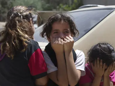 Gadis-gadis kecil Palestina berkabung sebelum pemakaman paman mereka yang terkena serangan udara Israel (14/07/2014) (AFP PHOTO/MAHMUD Hams)