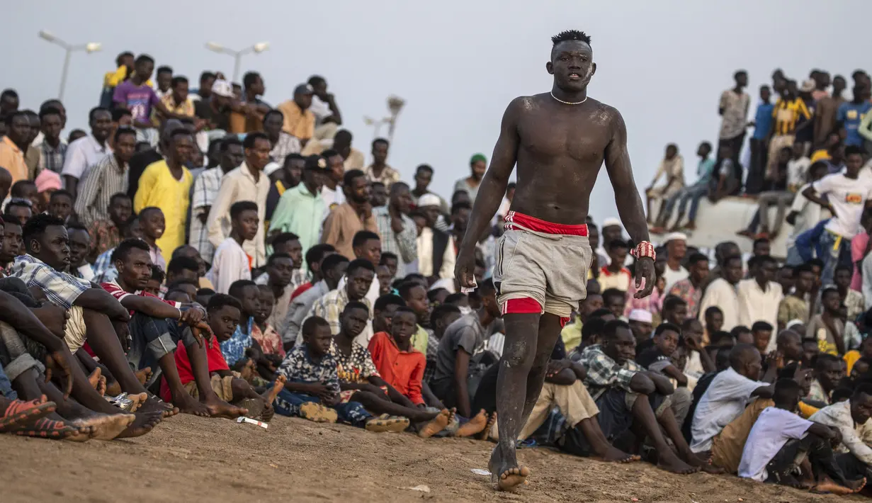 Seorang pegulat mendekati arena saat kompetisi gulat tradisional Nuba antara tim dari daerah Haj Youssef dan Omdurman di Ibu Kota Khartoum, Sudan, 30 Juli 2021. (Abdulmonam EASSA/AFP)