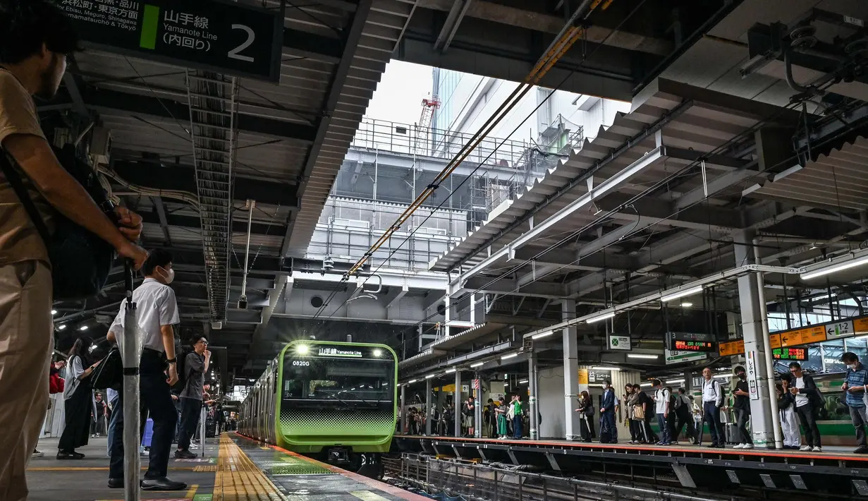 Melewati rute melingkar dengan waktu tempuh rata-rata 64 menit, Yamanote Line berhenti di 30 stasiun. Foto yang diambil pada tanggal 28 Juni 2024 ini menunjukkan orang-orang yang menunggu di peron saat kereta Yamanote Line memasuki stasiun Shibuya, salah satu dari 30 stasiun di sepanjang JR Yamanote Line di Tokyo.  (Richard A. Brooks/AFP)
