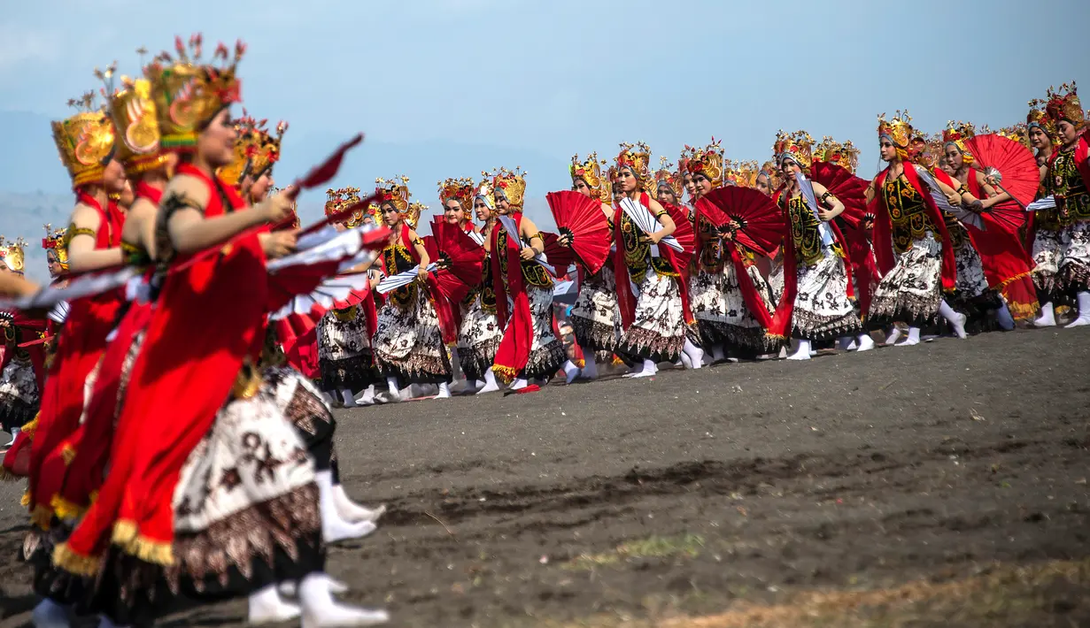 Penari tampil pada aksi tari kolosal Gandrung Sewu di Pantai Boom, Banyuwangi, 12 Oktober 2019. Dengan mengenakan busana menyala, ribuan penari dari berbagai usia mampilkan keindahan gerak tari Gandrung Sewu. (Juni Kriswanto/AFP)
