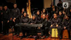 Konduktor Addie MS (tengah kanan) memimpin orkestra grup musik Light Ministry Orchestra (LMO) dan Light Ministry Ensemble (LME), yang mayoritas siswanya berkebutuhan khusus, saat konser A Night of Light di Jakarta, Minggu (19/11/2023). (Liputan6.com/Angga Yuniar)