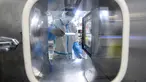 Seorang teknisi laboratorium yang mengenakan alat pelindung diri (APD) bekerja pada sampel yang akan diuji untuk virus corona Covid-19 di laboratorium Mata Api, fasilitas pengujian Covid-19, di Wuhan di provinsi Hubei tengah China (5/8/2021). (AFP/STR)