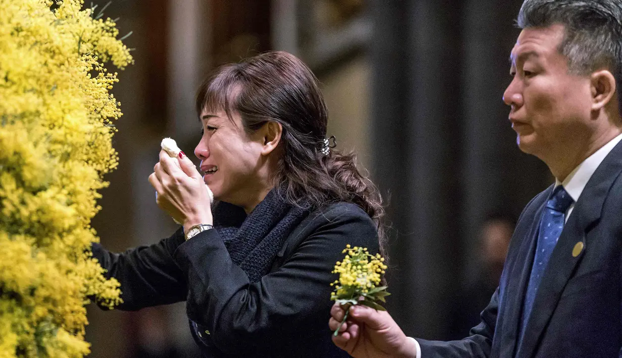 Para anggota keluarga korban meneteskan air mata saat meletakkan karangan di Katedral St Patrick, Australia, Kamis (7/8/14). (REUTERS/Mark Dadswell)