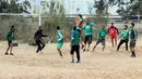 Sejumlah pria bermain sepak bola di lapangan tanah sebelum buka puasa selama bulan Ramadhan, di ibu kota Libya, Tripoli (24/4/2021). (AFP/Mahmud Turkia)