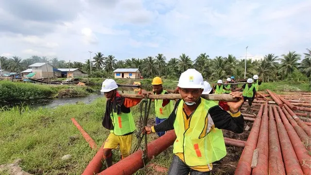 Minimnya infrastruktur membuat karyawan PLN harus memikul tiang-tiang listrik seberat ratusan kilogram (kg) untuk bisa menerangi wilayah di Natuna, (Liputan6.com/Nurseffi Dwi Wahyuni)