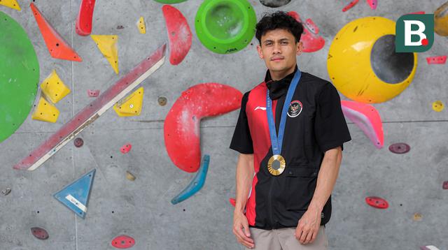 Atlet panjat tebing Indonesia, Veddriq Leonardo berfoto dengan medali emas Olimpiade Paris 2024 di markas FPTI, Hotel Santika Premier, Bekasi, Selasa (20/08/2024). (Bola.com/Bagaskara Lazuardi)