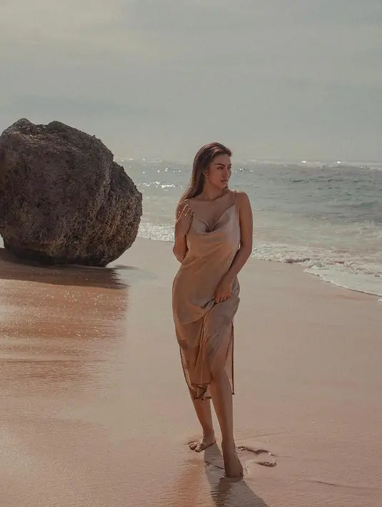 Nude silk dress untuk ke pantai bisa membuat penampilan Ariel Tatum semakin memukau.  (Instagram/arieltatum/anaditya_).