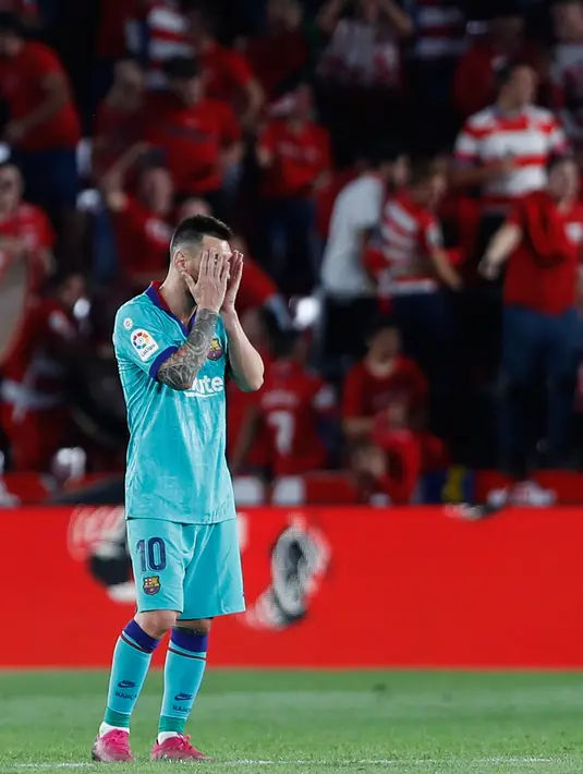 Bintang Barcelona, Lionel Messi menutup wajah dengan tangannya pada laga pekan kelima La Liga melawan Granada di Stadion Nuevo Los Cármenes, Sabtu(21/9/2019). Barcelona secara mengejutkan tumbang dalam lawatannya ke markas tim promosi, Granada 0-2. (AP Photo/Miguel Morenatti)
