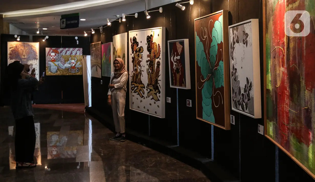 Pengunjung mengamati pameran seni rupa yang bertajuk 'Creative Freedom to Heal The Nation' di Perpustakaan Nasional, Jakarta, Kamis (15/10/2020). Pameran tersebut menceritakan refleksi kehidupan sehari-hari para seniman selama masa Pandemi COVID-19. (Liputan6.com/Johan Tallo)