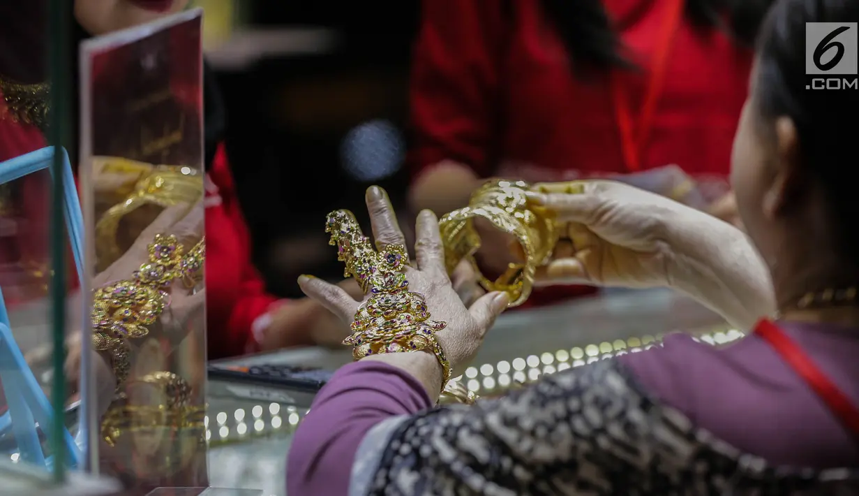 Pengunjung mencoba perhiasan di salah satu stan pameran JIJF 2019 di Jakarta, Kamis (4/4). Pameran ini bertujuan mempromosikan produk-produk perhiasan dengan ciri khas desain etnik budaya dengan menggunakan teknologi masa kini dalam industri perhiasan Tanah Air. (Liputan6.com/Faizal Fanani)
