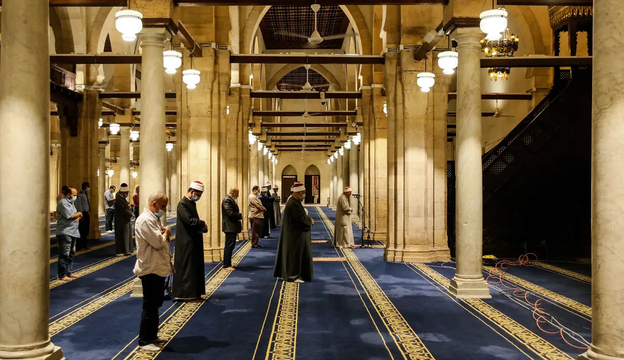 Umat Muslim melaksanakan salat tarawih dengan menerapkan jaga jarak selama bulan Ramadan di Masjid al-Azhar, Kairo, Minggu (17/5/2020). Bagi umat Islam di seluruh dunia menjalankan ibadah puasa tahun ini di tengah pembatasan akibat corona Covid-19 adalah yang pertama kalinya. (Samer ABDALLAH/AFP)
