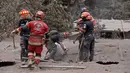 Tim penyelamat membongkar atap rumah warga untuk mencari korban dari letusan gunung Feugo di desa San Miguel Los Lotes, Guatemala (5/6). (AFP/Johan Ordonez)