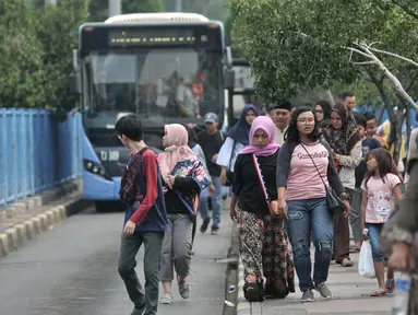 Penumpang menelusuri trotoar usai turun dari bus Transjakarta di Terminal Blok M, Jakarta, Minggu (1/7). Halte bus Transjakarta pertama di Ibu Kota ini kini terlihat kurang terawat dan minim sarana prasarana bagi penumpang. (Merdeka.com/Iqbal S. Nugroho)