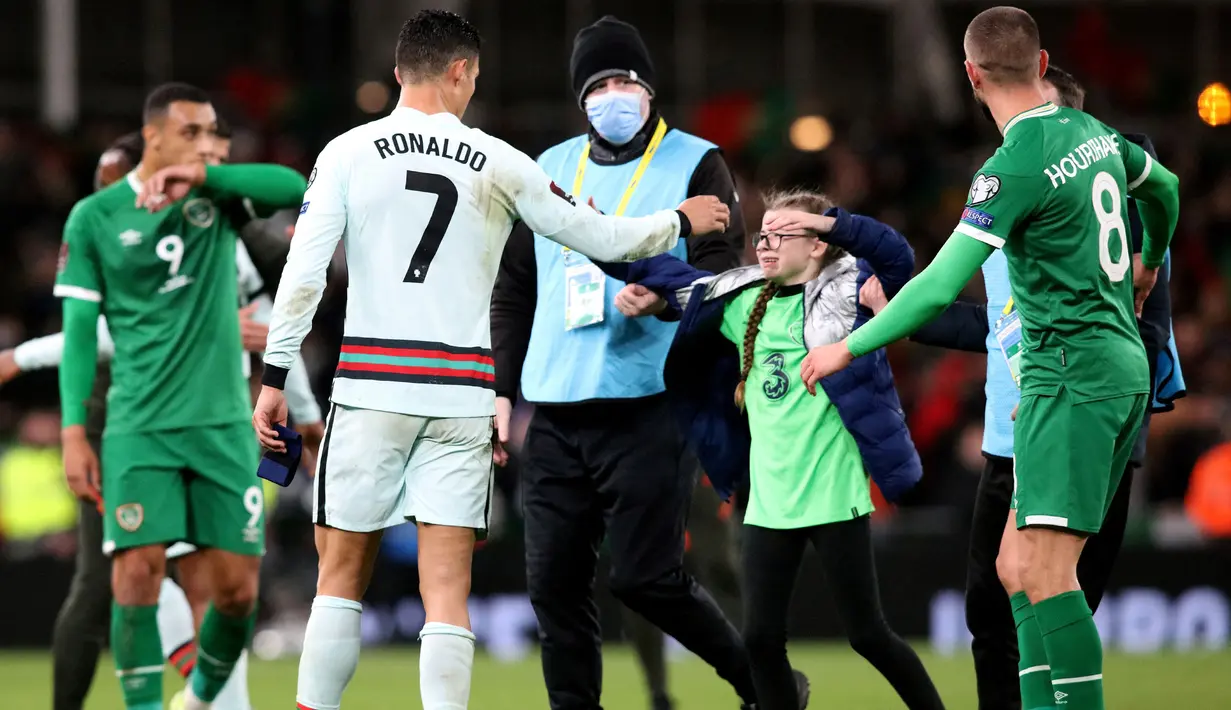Gadis berbaju jersey latih Timnas Republik Irlandia tersebut datang dari pinggir lapangan dan berusaha diamankan oleh sejumlah petugas keamanan Stadion Aviva. (AFP/Paul Faith)