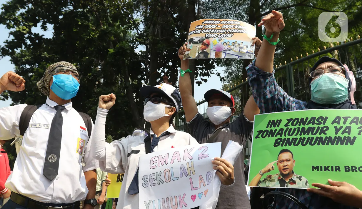 Sejumlah orang tua murid membawa poster dalam demonstrasi di depan Kementerian Pendidikan dan Kebudayaan, Jakarta, Senin (29/6/2020). Mereka memprotes sistem Penerimaan Peserta Didik Baru (PPDB) DKI Jakarta yang seleksi penerimaannya berdasarkan usia. (Liputan6.com/Herman Zakharia)