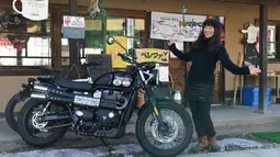 Reiko Miyoshi (60) berpose di samping motor Triumph Street Scrambler miliknya di luar "Perefa Cafe" di Matsumoto, prefektur Nagano (23/2). Pada 1976, ia mengelilingi Jepang dengan motor Suzuki Hustler TS250 selama 365 hari. (AFP Photo/Toshifumi Kitamura)