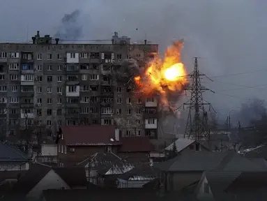 Sebuah ledakan terlihat di sebuah gedung apartemen setelah tank tentara Rusia menembak di Mariupol, Ukraina, pada Jumat (11/3/2022). Invasi Rusia ke Ukraina sudah memasuki hari ke-16 pada hari Jumat ini. (AP Photo/Evgeniy Maloletka)