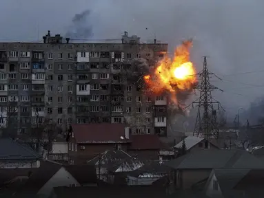 Sebuah ledakan terlihat di sebuah gedung apartemen setelah tank tentara Rusia menembak di Mariupol, Ukraina, pada Jumat (11/3/2022). Invasi Rusia ke Ukraina sudah memasuki hari ke-16 pada hari Jumat ini. (AP Photo/Evgeniy Maloletka)