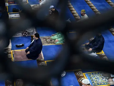 Umat muslim menjaga jarak saat salat Jumat usai pencabutan pembatasan Covid-19 di Masjid Al-Istighfar, Singapura, Jumat (26/6/2020). Masjid-masjid di Singapura telah diizinkan menggelar salat berjamaah, seiring memasuki pekan kedua dari Tahap Dua pembukaan kembali di negara itu. (Roslan RAHMAN/AFP)