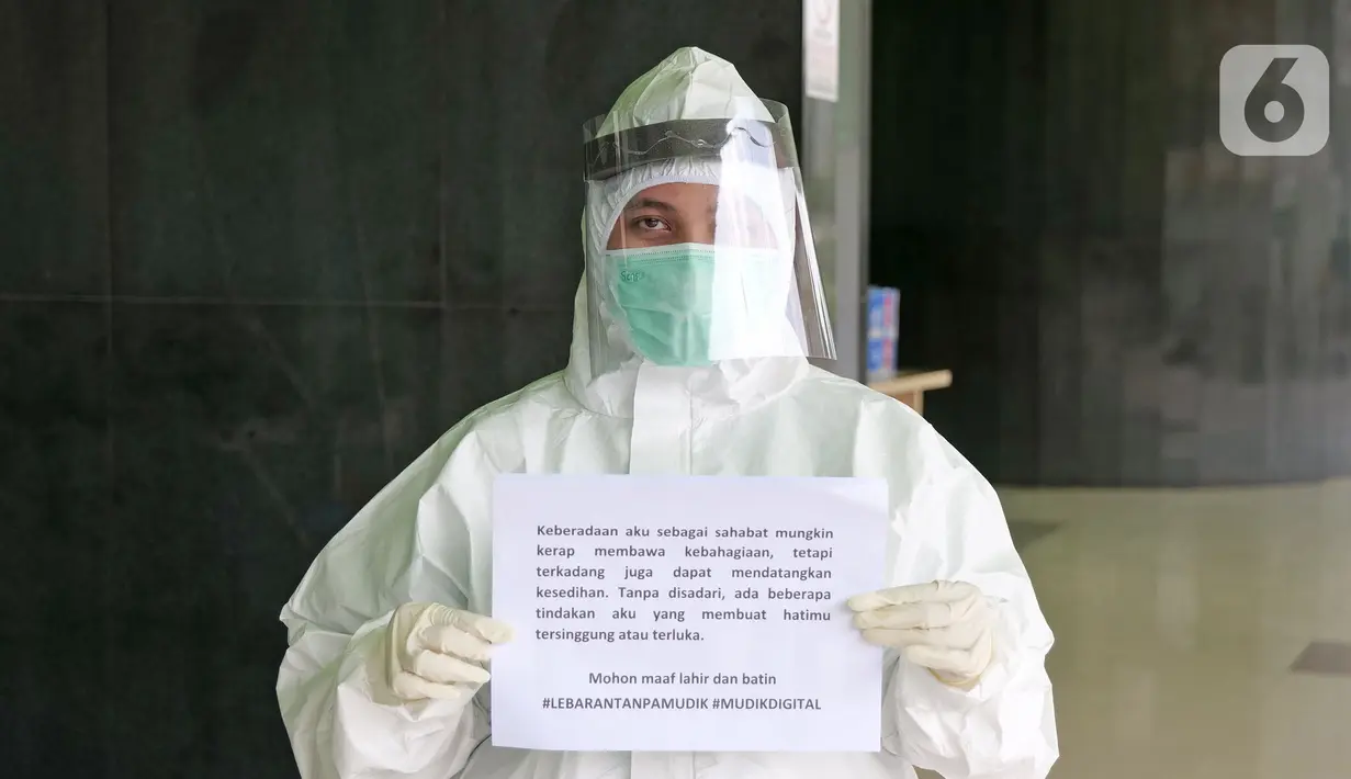 Petugas labotarium Nova Devi Manurung (24) menyampaikan pesan lewat sebuah tulisan saat di RSUD Pasar Minggu, Jakarta, Jumat (22/5/2020). Sejumlah garda terdepan Covid-19 menyampaikan pesan lewat sebuah tulisan. (Liputan6.com/Herman Zakharia)