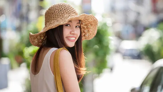 perempuan traveling bahagia tersenyum