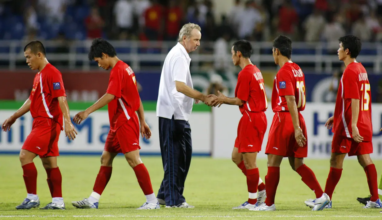Pelatih Vietnam Alfred Riedl (tengah) berjabat tangan dengan para pemainnya usai pertandingan Grup B Piala AFC antara Jepang dan Vietnam di Hanoi, Vietnam, 16 Juli 2007. Riedl dikenal sukses melatih beberapa negara Asia Tenggara seperti Laos dan Vietnam. (LIU JIN/AFP